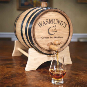 Custom engraved oak whiskey aging barrel with distillery logo pouring whiskey into a Glencairn glass, ideal for distillery branding, barrel-aged cocktails, and bar marketing displays